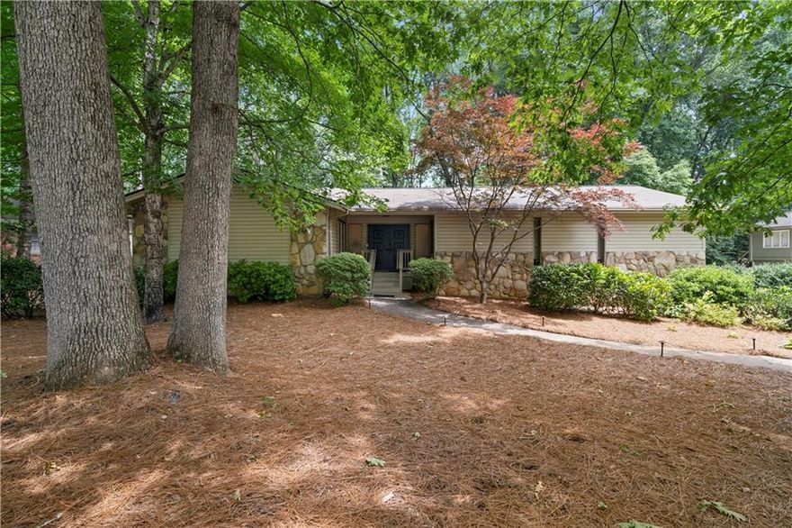 This beautiful raised ranch offers timeless charm and spacious living across two levels. Enter through a dramatic double door foyer with frosted glass windows and stone flooring. The impressive great room features vaulted natural wood beam ceilings, a wall of built-ins, floor to ceiling windows, and a striking stone fireplace, perfect for entertaining or relaxing. Enjoy outdoor living on the spacious deck with built-in bench seating, just off the great room. The kitchen is both stylish and functional with granite countertops, abundant cabinetry, stainless steel cooktop, wall oven, and a bay window breakfast nook. A separate dining room offers space for gatherings of 8+ with generous natural light. The main level includes three bedrooms, including a primary suite with double vanities and a gorgeous shower. A bath with a marble top vanity and tub/shower combo is shared between the other two bedrooms, and a convenient hallway half bath. The finished lower level is a true retreat, perfect as the second primary or an in-law suite complete with a large bedroom featuring tray ceilings, a cozy sitting area with a stone accent wall and fireplace, an expansive ensuite with double vanities, a marble soaking tub, walk-in shower, and huge custom closet. Lower level also features a laundry room, extra storage/workshop with plumbing, and access to a private covered deck. Finished off with a 2 car drive under garage and a new HVAC system, this home is a rare blend of character, comfort, and space!