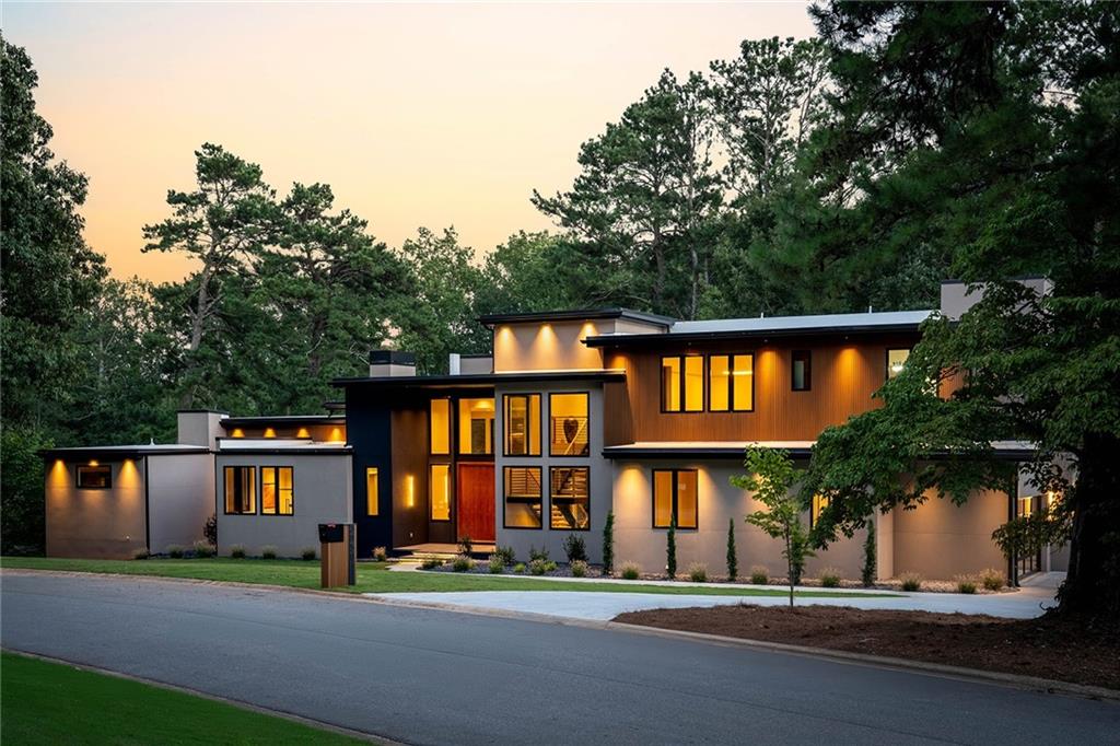 Situated within the prestigious Indian Hills Country Club and located in the highly sought-after Walton High School district, this exceptional modern residence epitomizes luxury and sophistication. Set on a premier golf-front cul-de-sac lot with sweeping views, this home offers three impeccably finished levels of bespoke craftsmanship and an unparalleled amenity package, catering to the most discerning of buyers. The main level is a masterclass in open-concept living, with soaring ceilings and wide plank oak flooring that accentuate the grandeur of the space. The dramatic fireside family room, complete with a cocktail seating area and wet bar, is an entertainer’s paradise. The state-of-the-art kitchen features exquisite two-tone cabinetry, waterfall countertops, and a SubZero and Wolf appliance package, including separate refrigerator and freezer columns. Adjacent to the kitchen is a fully equipped scullery, outfitted with a suite of professional-grade appliances—refrigerator, oven, stove, dishwasher, and ample cabinetry—designed to cater to every culinary need. The main level’s primary suite is a true retreat, offering a morning bar and a spa-inspired bathroom adorned with large-format tile flooring, a walk-in wet room featuring an oversized shower and floating soaking tub, dual vanities, a make-up counter, dual water closets, and a beautifully custom-designed closet. Completing the main level are a glass-enclosed office, an opulent guest suite with an ensuite bathroom, a formal powder room, a well-appointed laundry room, and a dedicated pool bathroom. A striking wall of nano accordion doors seamlessly extends the living space to a covered fireside veranda and an infinity-edge saltwater pool and spa, all overlooking the tranquil golf course. Upstairs, luxury continues with four ensuite bedrooms, a grand fireside bonus room, and a spacious rooftop terrace perfect for al fresco gatherings. The upper level also includes an additional laundry room and a powder room, ensuring convenience at every turn. The fully finished terrace level is a haven for entertaining, featuring an open-concept media room, glass-enclosed gym, fully equipped sports bar, lounge, family room, powder room, and a guest suite, all designed with the same meticulous attention to detail found throughout the home. Further enhancing the residence are the conveniences of a three-stop elevator and a three-car garage. This home is more than just a place to live—it is a statement of refined living, designed for those who demand the extraordinary, set in one of the most coveted locations within the esteemed Indian Hills community.