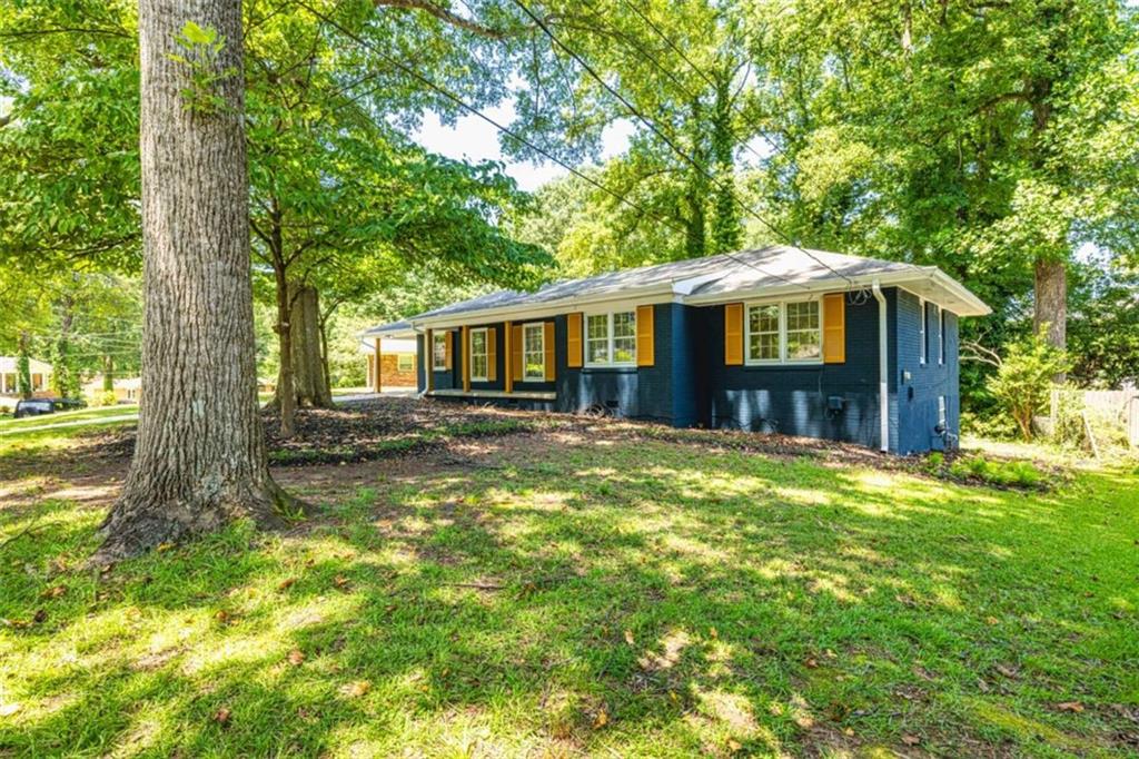 Step into this beautifully reimagined 1962 brick ranch where timeless character meets top-to-bottom renovation! Every inch of this 3-bedroom, 2-bath beauty has been updated with care and style. The original hardwood floors shine like new, adding warmth and elegance throughout the home. Enjoy a brand-new kitchen featuring custom cabinets, granite countertops, and stainless steel appliances-all tied together with durable luxury vinyl flooring that flows into the spacious dining room and sun-soaked den. Both bathrooms have been fully transformed with modern tile showers, sleek vanities, and updated fixtures. Major upgrades include a complete electrical rewire with a new panel, updated plumbing (no more cast iron!), and a recently serviced HVAC system. The roof is only 10 years old, and the carport includes a large storage room and dedicated laundry area. Tucked on a level lot, this move-in ready home offers an extra-large family room perfect for entertaining, relaxing, or both. Don't miss this rare opportunity to own a classic ranch with all the modern upgrades-without sacrificing charm! Just 11 minutes to Hartsfield-Jackson International Airport and only 20 minutes to the heart of Downtown Atlanta! Whether you're a frequent traveler or commuting to the city, this home's location offers quick and easy access to I-285, I-85, and I-75-or a short walk to public transportation putting everything Atlanta has to offer right at your fingertips. ***Motivated Seller*** - priced below appraised value
