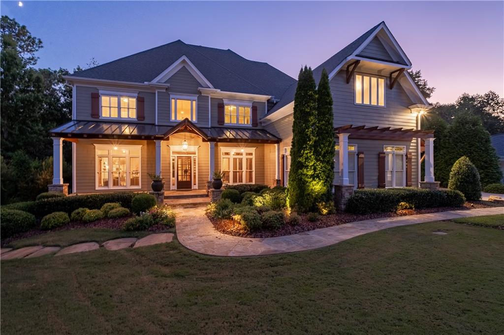 Welcome to 775 Lake Mist Cove — a one-of-a-kind 7,018 sq ft luxury estate on a peaceful 1.6-acre lot in Providence at Atlanta National, a premier gated and guarded Milton community. Built with timeless elegance and the highest standards, this stunning home offers privacy, tranquility, and refined finishes — just minutes from top-rated schools, equestrian centers, and all that Milton has to offer. From the moment you arrive, the attention to detail is clear. A stately stone walkway leads to a grand covered front porch. Inside, the main level features a dramatic two-story foyer and great room with soaring windows and a fireplace. From the kitchen and patios, you’ll enjoy serene views of your private backyard oasis — a daily invitation to relax and feel at home. The main floor also includes a separate dining room, private office, mudroom, guest suite with full bath, and a powder room — blending function with sophistication. Dual staircases, site-finished hardwoods, detailed millwork, and expert craftsmanship elevate every space. The expansive white kitchen features Sub-Zero and Thermador appliances, quartz countertops, marble backsplash, a sunlit breakfast nook, and a keeping room with a stone fireplace — perfect for casual gatherings. A cozy year-round sunroom includes a stone fireplace and windows that open to bring in the breeze. The home boasts seven fireplaces — a true mark of custom design and comfort-first living. Upstairs, the owner's suite is a retreat with a fireplace, sitting area, tray ceiling, built-ins, and two spacious walk-in closets. The fully renovated primary bathroom is magazine-worthy — with dual vanities, a barrel ceiling with chandelier, freestanding soaking tub, large tiled shower with multiple heads, and two linen closets. Three additional bedrooms complete the upper level — one with an en suite, two with a Jack-and-Jill layout. The walk-out, daylight terrace level is a full extension of the home, with high ceilings, recessed lighting, luxury carpet, and LVP flooring. It offers three flexible spaces for bonus bedrooms, a gym, home theater, or golf simulator. One soundproof room includes a green screen wall — ideal for video production, podcasting, or a creative studio. With a full bath and exterior access, this level offers potential for private living or studio space. There’s also a large open area, sunroom, and covered porches leading to a professionally designed backyard patio — ideal for multi-generational living, nanny/in-law quarters, or a private office. Outdoor living is unmatched, with five thoughtfully designed porches, two sunrooms, and extensive hardscaping. A grand stone fireplace with chimney and hearth anchors the private, wooded backyard — a showstopping space for entertaining or peaceful evenings. With acres of woods behind and zero road noise, the serenity is unmatched. Yet, you’re just minutes from GA-400, parks, trails, top schools, and the vibrant dining and entertainment scenes of Avalon, downtown Alpharetta, Milton, and Crabapple Market. This is a rare opportunity to own a luxury home that blends elegance, flexibility, and comfort — thoughtfully designed for how you live, grow, and thrive.