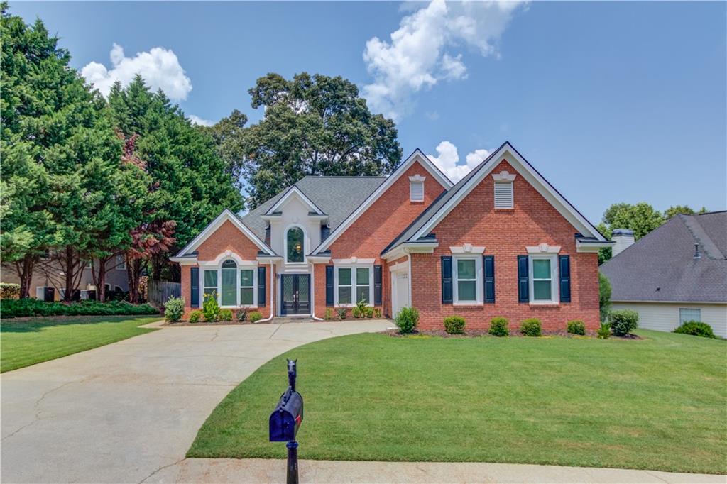 Ranch home in the North Gwinnett school district in Sugar Hill. Step into a welcoming formal living and dining area just off the foyer. The vaulted great room features a cozy gas fireplace and offers plenty of space to accommodate oversized furniture comfortably. The kitchen boasts granite countertops, a stylish tile backsplash, and stainless steel appliances. The oversized primary suite impresses with a double tray ceiling and abundant natural light. The remodeled ensuite bath is truly spa-worthy, featuring an extended tile shower with frameless glass, granite-topped vanities, updated lighting and plumbing fixtures, and a freestanding clawfoot tub to complete the luxurious design. Enjoy a spacious laundry room with updated cabinets and countertops for easy folding. The entire home has been freshly painted and features updated lighting throughout. The fenced backyard offers a level lawn, refreshed landscaping, and a large concrete patio ideal for outdoor living. Located in a swim & tennis community with quick access to GA-400, I-85, the Mall of Georgia, downtown Sugar Hill, and Suwanee.