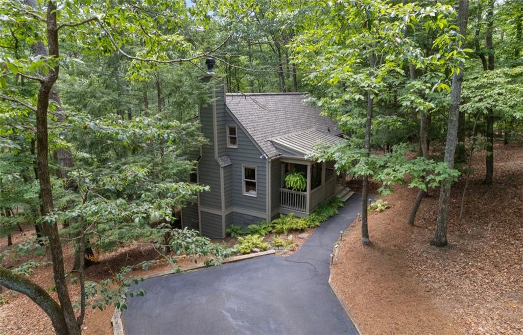 Enchanting Big Canoe Retreat: A Fairy-Tale North Georgia Mountain Escape! Every once in a while, a mountain hideaway so magical appears that you can't believe it's real-and it could be yours! Nestled like a storybook cottage amidst gentle Hemlock trees, this cabin's enchanting pathways and inviting front porch feel like it has come straight out of a fairy tale. Step inside, and a soaring stone fireplace and wide plank wood flooring instantly steal the spotlight, while a wall of sunlit windows frames your own private woodland oasis with seasonal mountain views. You'll Fall in Love With the Worry-Free Upgrades ~ HardiPlank siding, new roof, and freshly painted decks offer clean, low-maintenance peace of mind. Freshly painted interior throughout ~ Stylish & Relaxed Interiors ~ Updated baths, all new and carefully selected light fixtures, wide planked heart pine floors, contemporary new carpet in the owner's suite, double paned windows ~ Inviting kitchen with charming coffee nook, all new stainless appliances, eat-in bar and a built-in purified water dispenser. ~ Breathtaking Gathering Space ~ Striking floor to ceiling stone, wood-burning fireplace sets a cozy, dramatic focal point. A full wall of windows bathe the space in morning light-and showcase panoramic forest views. A partially open concept kitchen ensures conversation and privacy. ~ Seamless Indoor-Outdoor Living ~ Private owner's suite opens onto a screened porch-perfect for starlit evening relaxation. An expansive open-air deck stretches along the home, ideal for morning coffee or sunset unwinding. Located close to some of Big Canoe's most sought after trails and waterfalls. Imagine crisp mountain evenings, the comforting glow of a crackling fire, and birdsong drifting in. This isn't just a cabin-it's your personal forest sanctuary-perfectly refined with modern touches and timeless north Georgia mountain charm. Are You Ready to Fall in Love? Homes like this vanish fast. Big Canoe is a sought after resort like gated, mountain community with golf, tennis, pickleball, lakes, swimming, fishing, boating, hiking and a fantastic restaurant and clubhouse. It's time to move to the mountains!