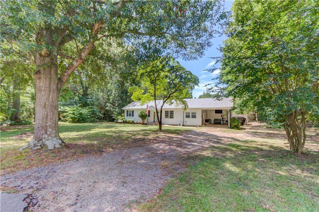 Discover the charm of country living with modern updates in this inviting ranch-style home on 1.1 level acres in Danielsville. Thoughtfully refreshed, this 3-bedroom, 1-bath home features new flooring, fresh paint, and a bright, open kitchen—perfect for both everyday living and entertaining. A spacious bonus room, currently used as the primary bedroom, offers added flexibility and comfort with its own HVAC mini-split system.
Significant upgrades in 2020 include a new roof, vinyl siding, hot water heater, and updated appliances. There is also plumbing in place beneath the laundry area for a future half bath, providing an easy opportunity for expansion.
Outside, enjoy the privacy of mature shade trees, a peaceful backyard ideal for gardening or play, and a partially enclosed workshop perfect for storage or hobbies. Conveniently located on Hwy 98 with quick access to Commerce, I-85, and Athens, this home blends small-town charm with everyday convenience.