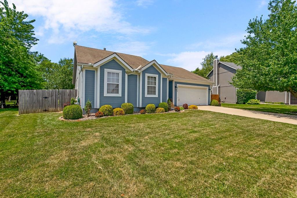 View of front of home with concrete driveway and an attached garage